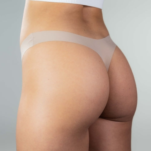 Close-up side view of model wearing Gudia sand seamless thong, soft stretch fabric and seamless fit for smooth, invisible comfort