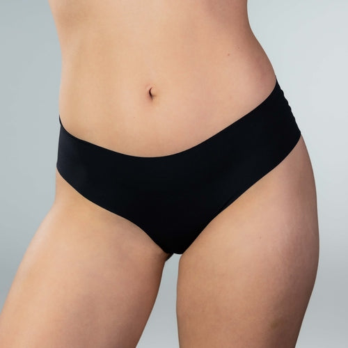Front view of model wearing Gudia black seamless Brazilian underwear with clean cut edges and breathable organic cotton crotch for all-day comfort