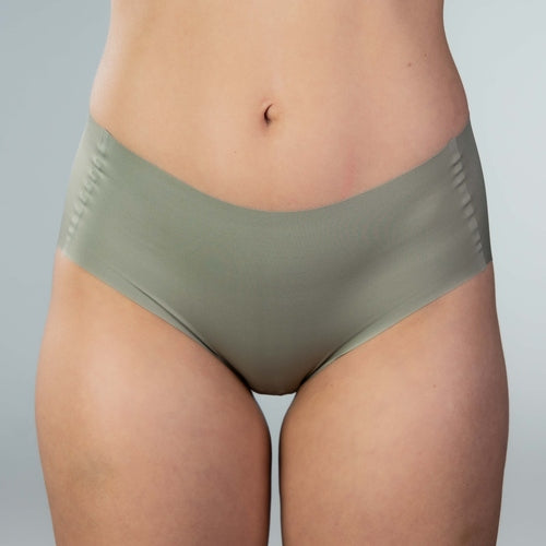 Front close-up of model wearing Gudia green seamless hipster with mid-rise V-shaped waistband and organic cotton crotch for breathable everyday comfort