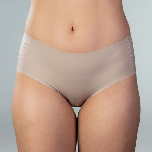 Front view of model wearing Gudia sand seamless hipster with mid-rise V-shaped waistband and organic cotton crotch for soft breathable daily comfort