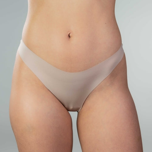 Close-up front view of model wearing Gudia sand seamless thong, smooth V-shaped waistband and seamless font for irritation free comfort.