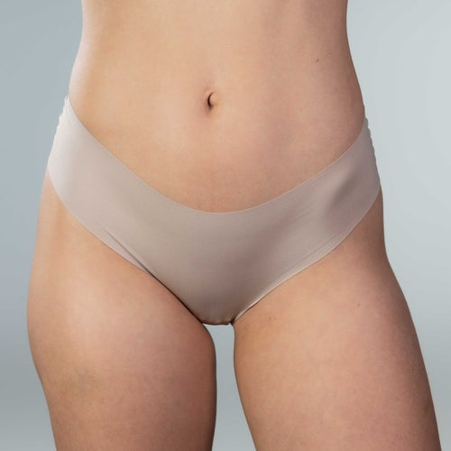 Front close-up view of model in Gudia sand seamless Brazilian underwear designed with soft waistband and organic cotton crotch for breathable daily wear