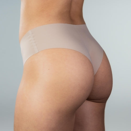 Side view of model wearing Gudia sand seamless Brazilian underwear with smooth edges, soft waistband and breathable organic cotton crotch for invisible comfort