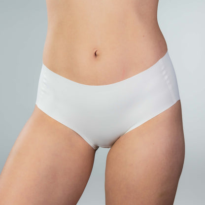 Front view of model wearing Gudia white seamless hipster with mid-rise V-shaped waistband and organic cotton crotch for soft breathable comfort