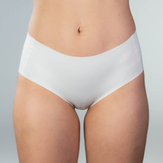 Front view of model wearing Gudia white seamless hipster, mid-rise V-shaped waistband and organic cotton crotch for soft, breathable comfort